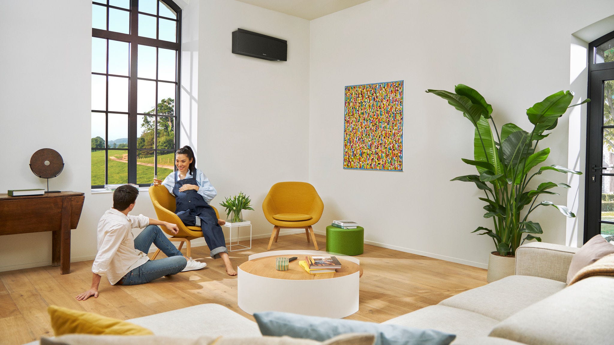 Ett par som väntar barn pratar avspänt med varandra medan kvinnan sitter på en stol