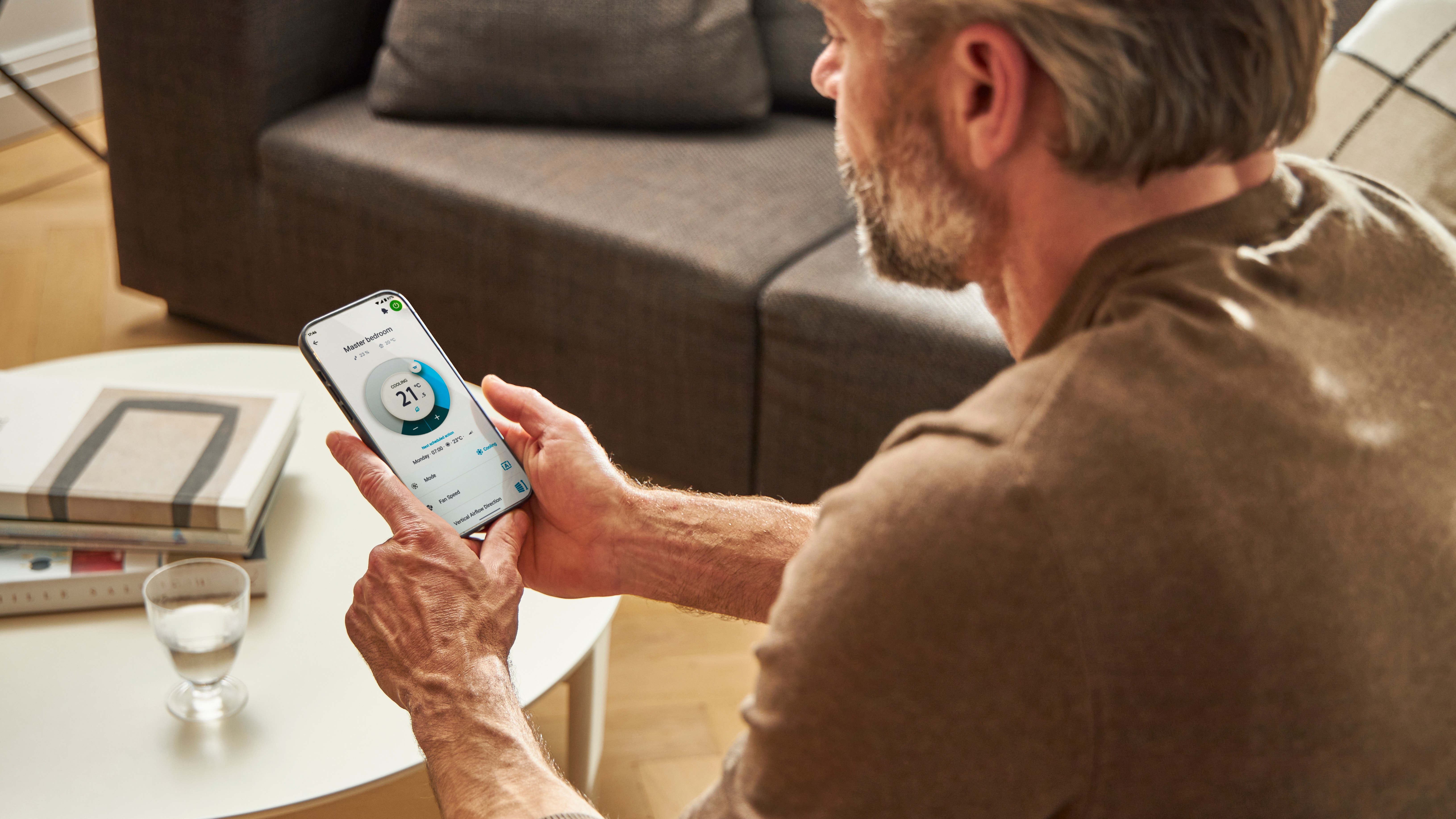 En man använder en app för att styra sin värmelösning