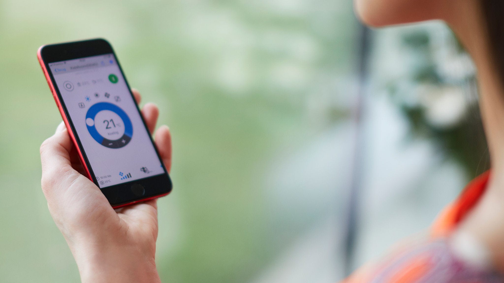 En kvinna som använder en app för att styra sin värmelösning