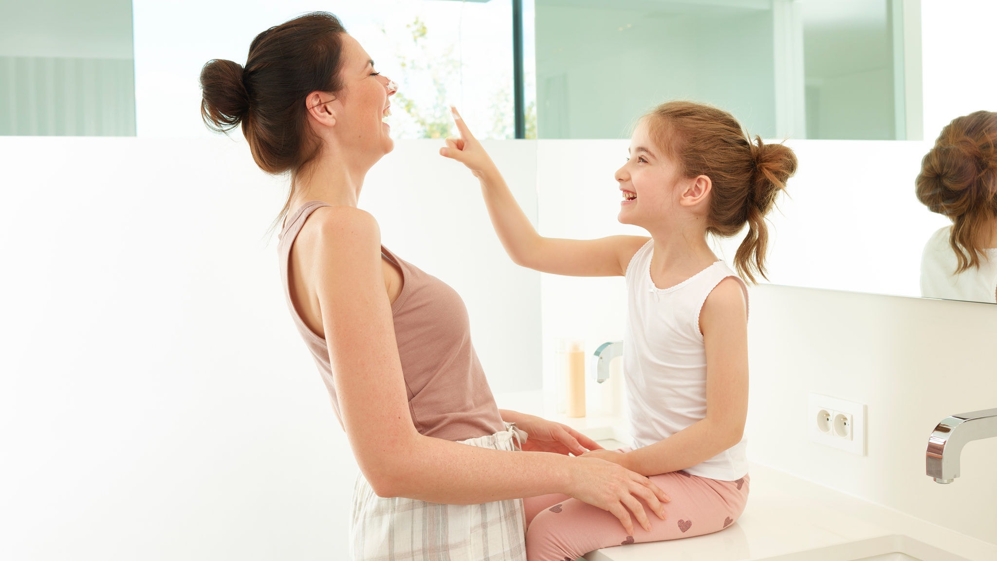 Mor och dotter som leker i badrummet