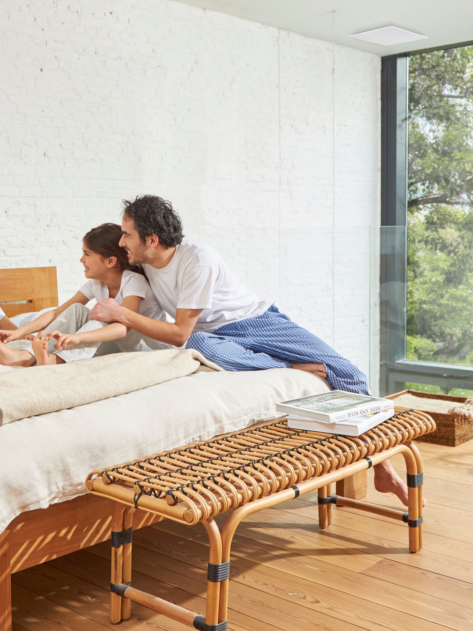 Pappa och dotter på en säng i ett välventilerat rum